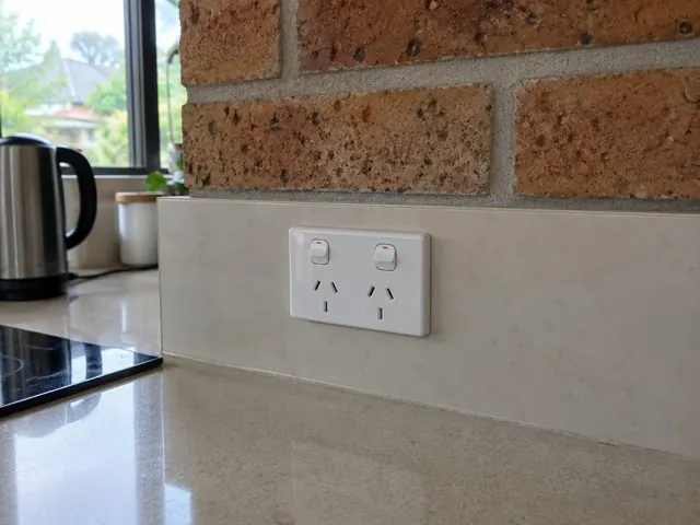 Double power point on a tiled kitchen splashback beside a benchtop in St Ives