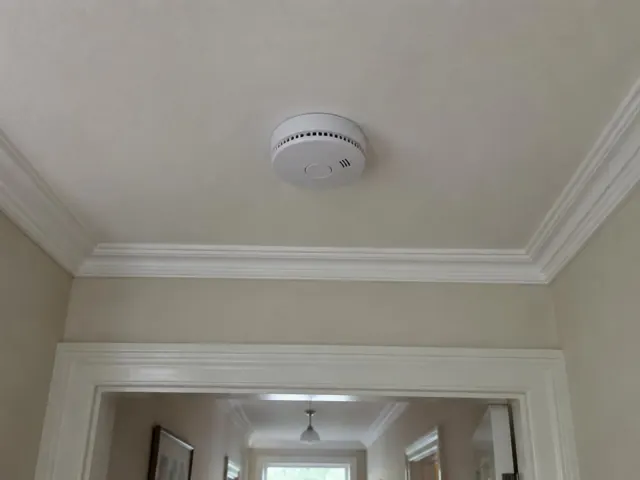 Ceiling smoke alarm in a hallway with decorative cornice in Hornsby